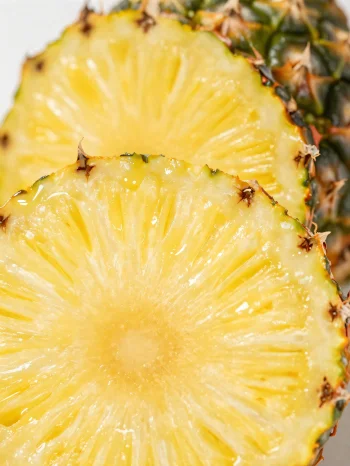 Svež, narezan ananas na rustikalni leseni mizi