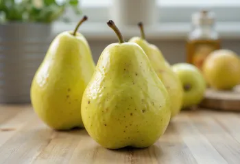 Sveže zelene in rumene hruške na rezalni deski, cele in narezane