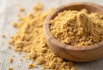 Ashwagandha v prahu v majhnem kozarcu, zemeljsko rjave barve, obdana s svežimi koreninami ashwagandhe