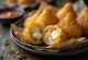 Coxinha brez mesa, postrežena s svežim koriandrom in v hrustljavi panadi.