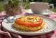 Welsh rarebit s paradižnikom, okrašen z rezino pečenega paradižnika na vrhu sirne omake.