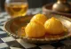 Rasgulla z žafranom, skutine kroglice, ki plavajo v žafranovem sirupu