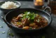 Curry goat s česnom, pripravljen s kokosovim mlekom, postrežen s svežim koriandrom