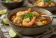 Pozole con mariscos postrežen z limeto, koriandrom in mlado čebulo