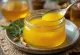 Ghee s kurkumo v kozarcu, okrašen s svežo kurkumo